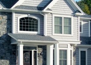 The Front of a Suburban Home With Gray Siding and Attractive Windows 